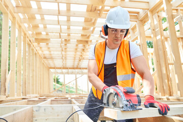 Craftsman, builder standing, looking down, cutting wodden gilder by professional equipment.