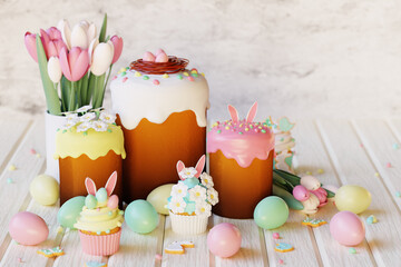 Easter cakes, cupcakes, eggs and gingerbread cookies on white wooden table. 3d render