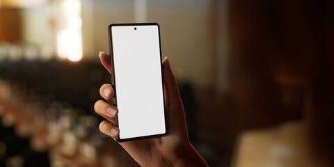 CU 20s Caucasian female holding a phone in a right hand, vertical orientation