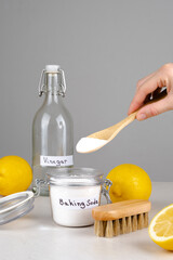 Baking soda, vinegar and lemon on a gray background.The concept ecological cleaning, disinfecting,...