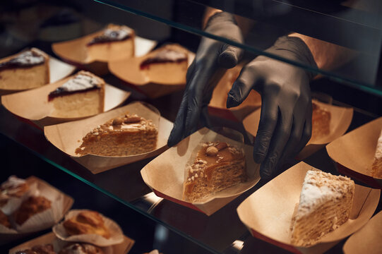 Close up view of man's hands in gloves that taking delicious desserts