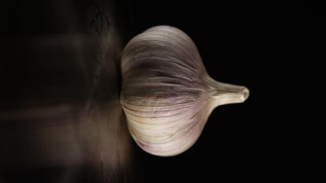 Garlic bulbs on black background &ndash; vertical food video