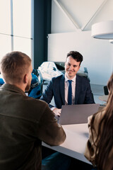 The manager during the paperwork on the laptop about the sale of a new car. Buying a family car