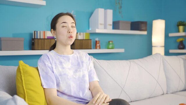 Happy and peaceful Asian young woman whistling at home.
Delightful and peaceful Asian young woman whistling.
