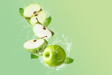 Creative layout made from Green Apple and water splashing on a pastel green background. Fruit minimal concept and copy space.