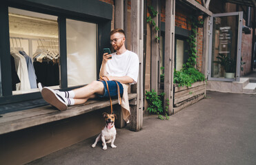 Bearded man resting on bench with dog