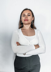 A confident business woman in a white sweater and black pants. Crossed hands.