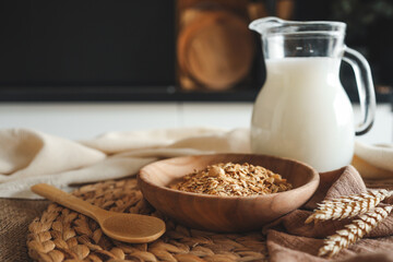 Wooden bowl with granola and jug of milk, breakfast concept