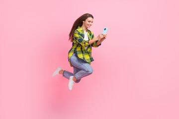 Full body photo of attractive sporty lady jump rush use smart phone isolated on pink color background