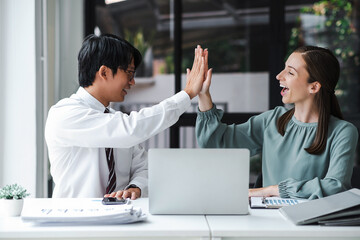 Business people celebrate with laptop success happy pose. E-commerce, internet technology, or startup small business concept. Modern office