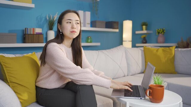 Asian young woman afraid and suspicious at home.
Asian young woman hearing strange noises at home scared and worried.

