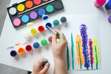 Children's drawing with paints top view, hands with paints