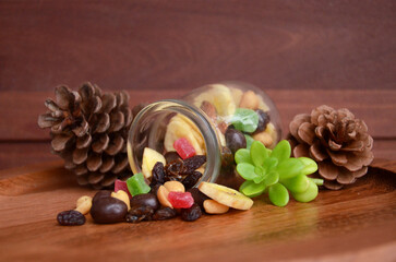 Mix of dried fruit in transparent jar. wooden background
