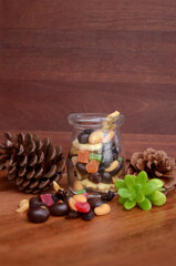 Mix of dried fruit in transparent jar. wooden background