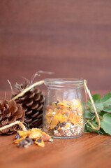 Granola in transparent jar with succulents. Rustic wood background