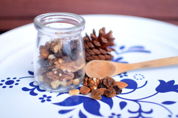  Transparent jar of Dried fruits and mix nuts with wood background and white plate 