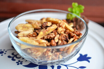 Bowl of nuts in a plate with wood background