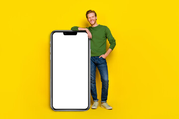 Fototapeta na wymiar Full length photo of sweet charming guy dressed sweater modern device empty space isolated yellow color background