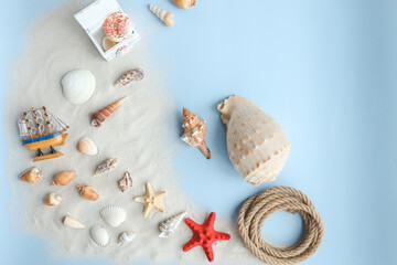 Fototapeta na wymiar Marine summer composition. Shells, ship, rope on a blue background
