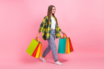 Full body length photo of walking model shopaholic lady young age hold much bags package new store boutique adidas isolated on pink color background