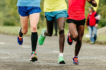 Fototapeta premium two african and european runners running marathon, front view legs jogger run world championships race