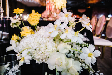 Composition flowers, candles, candlesticks on floor hall restaurant. Table setting, setup.  Birthday, baptism, event. Trendy decor. Luxury wedding reception. Golden rich interior with light at night.