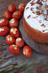 Easter food background. Red dyed eggs with onion peel and clover and dill leaves. Easter cake on a wooden table. Spring homemade DIY craft concept. Colored home simple brown egg top view.