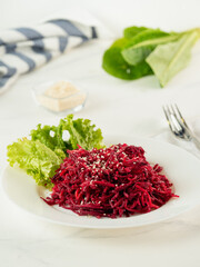 Beetroot salad on white table, vertical