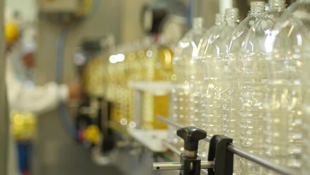 Factory worker organicing plastic bottles in the product line of Industrial factory