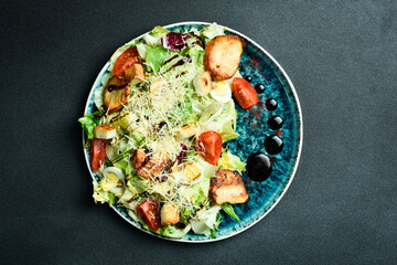 Caesar salad with chicken. Restaurant menu. On a dark background, close-up.