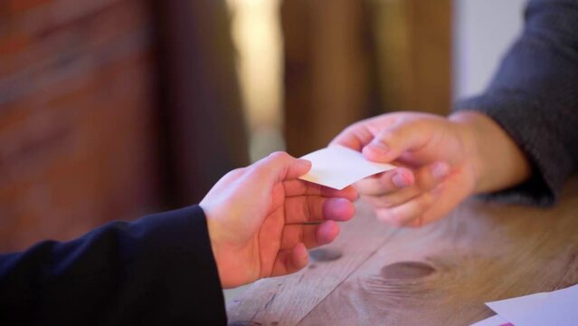 Insert of business card being exchanged. Slow motion 60fps.