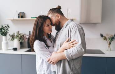 Fototapeta premium Happy couple hugging in kitchen