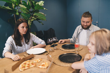 Parents looking at misbehaving teen daughter at dinner