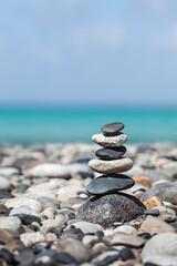Zen meditation background - balanced stones stack close up on sea beach