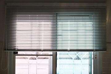 Details of white fabric roller blinds on the plastic window in the kitchen.
