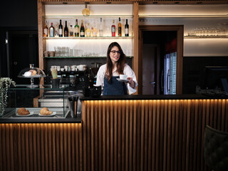 Fototapeta na wymiar A friendly barista giving coffee to a customer in a coffee shop.
