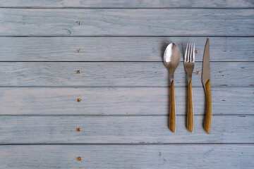 Spoon, fork and knife on a rustic wooden table