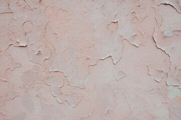 Peeling light pink wall of a building. Background, texture for design
