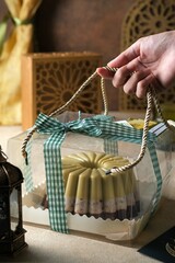 Avocado chocolate pudding in transparent box for hampers. The hand holding rope hampers box.