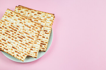 Traditional Jewish food matzo bread on a pink background. Happy Passover. Religious spring holiday Pesach. Copy space.