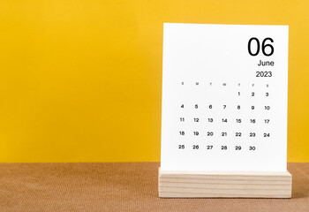 The June 2023 Monthly calendar for 2023 year on yellow table. - obrazy, fototapety, plakaty