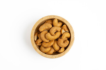 Salted cashews in a small wooden bowl on a white background. Cashew nuts are nutritious foods rich in protein and good fats.