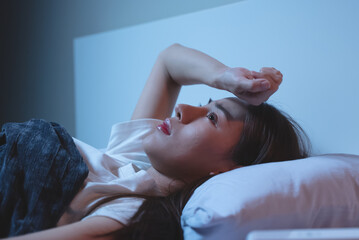 Asian women opened eyes lying on the bed have an insomnia problems. - obrazy, fototapety, plakaty