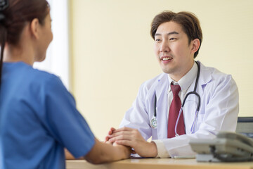 Fototapeta premium Asian doctor talking to patient with smile to encourage patients at the hospital