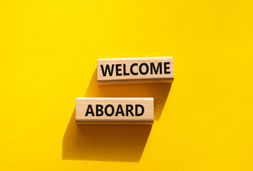Welcome aboard symbol. Concept word Welcome aboard on wooden blocks. Beautiful yellow background. Business and Welcome aboard concept. Copy space