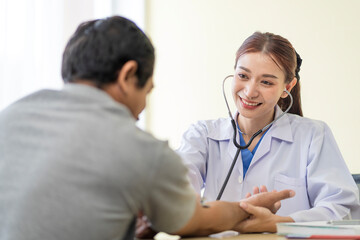 Asian doctor talking to patient with smile to encourage patients at the hospital