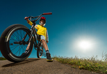 Teenager on a BMX bike in a skate park on a pump track.