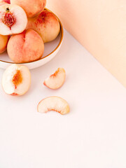 Tropical pastel composition of Japanese peaches on a plate. Ripe fruit is amazing for healthy diet snack to refresh the summertime days. Can be used as a background or a banner. Shallow depth of field