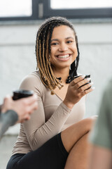 joyful african american with dreadlocks holding Chinese cup with puer tea.