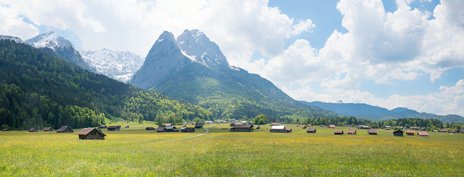 wide pasture with wooden hay huts, Wetterstein Alps. bavarian spring landscape